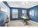 Home office with a desk, chair, and blue accent wall at 17806 Althea Blue Pl, Lutz, FL 33558