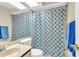 Clean bathroom with a shower/tub combo and patterned shower curtain at 2188 Elm St # 1107, Dunedin, FL 34698