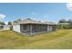 Home exterior showcasing a large screened porch and grassy backyard at 2234 Preservation Green Ct, Sun City Center, FL 33573