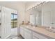 Bathroom with vanity, mirror, and access to screened porch at 2234 Preservation Green Ct, Sun City Center, FL 33573