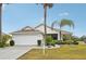 One-story house with white garage door and palm trees at 2234 Preservation Green Ct, Sun City Center, FL 33573