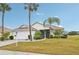 One-story house with white garage door and palm trees at 2234 Preservation Green Ct, Sun City Center, FL 33573