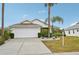 One-story house with white garage door and palm trees at 2234 Preservation Green Ct, Sun City Center, FL 33573