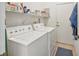 Functional laundry room with washer, dryer, and storage shelves at 2234 Preservation Green Ct, Sun City Center, FL 33573