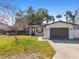 Newly renovated home with a gray garage door and well-maintained lawn at 2522 Krueger Ln, Tampa, FL 33618