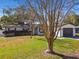 Brick home with gray garage door, landscaping, and a large tree in the front yard at 2522 Krueger Ln, Tampa, FL 33618