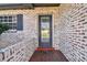 Front door entry with brick wall, gray door, and a welcome mat at 2522 Krueger Ln, Tampa, FL 33618