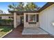 Updated front entrance featuring a brick walkway and a gray door at 2522 Krueger Ln, Tampa, FL 33618