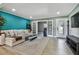 Spacious living room with teal accent wall, sectional sofa, and wood-look floors at 2522 Krueger Ln, Tampa, FL 33618