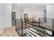 Open second-floor hallway with modern metal railing, hardwood floors and seating area at 2623 S Parkview St, Tampa, FL 33629