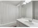 Bright bathroom with a large mirror, white vanity, and bathtub with white shower curtain at 28643 Seashell Ct, Wesley Chapel, FL 33545