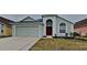 Attractive light teal house with a red door and two-car garage at 29325 Birds Eye Dr, Wesley Chapel, FL 33543