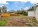 Large backyard with wooden fence and clear view of the house at 303 E 120Th Ave, Tampa, FL 33612