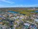 Expansive aerial view of a charming home near the waterfront, surrounded by lush greenery and a serene blue canal at 3075 Rosery Ne Rd, Largo, FL 33771