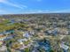 Expansive aerial view of neighborhood featuring lush landscaping, mature trees, and scenic waterway nearby at 3075 Rosery Ne Rd, Largo, FL 33771