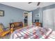 Cozy bedroom featuring blue walls, ceiling fan, and a colorful quilt-covered bed at 3075 Rosery Ne Rd, Largo, FL 33771