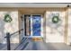 Charming front entrance features a blue door, a 'welcome' sign, and decorative wreaths for a warm and inviting appeal at 3075 Rosery Ne Rd, Largo, FL 33771