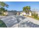 Charming single-story home with a well-manicured lawn, palm trees, and a wide driveway leading to a two-car garage at 3075 Rosery Ne Rd, Largo, FL 33771