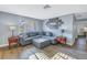 Cozy living room with a plush gray sectional sofa, wood floors, natural light, and stylish decor at 3075 Rosery Ne Rd, Largo, FL 33771