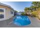 Sparkling in-ground pool surrounded by lush landscaping and a spacious patio area, adjacent to the home's exterior at 3075 Rosery Ne Rd, Largo, FL 33771