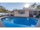 Large in-ground pool with an adjacent covered patio area with an outdoor dining area at 3075 Rosery Ne Rd, Largo, FL 33771