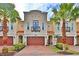 Tan three-story townhouses with brown garage doors, balconies, and palm trees at 3222 W Empedrado St, Tampa, FL 33629