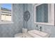 Small powder room with modern sink and geometric wallpaper at 33945 Landsman Loop, Wesley Chapel, FL 33543