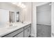 Bright bathroom with double sinks, gray cabinetry, and a large mirror at 33945 Landsman Loop, Wesley Chapel, FL 33543