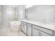 Bright, luxurious bathroom with a glass shower, soaking tub, and double vanity at 33945 Landsman Loop, Wesley Chapel, FL 33543