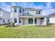 Back of home featuring an outdoor kitchen, covered patio, and large backyard space with lush green grass at 33945 Landsman Loop, Wesley Chapel, FL 33543