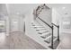 Bright foyer with a staircase, light gray wood-look tile floors, and a white front door at 33945 Landsman Loop, Wesley Chapel, FL 33543