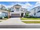 Charming two-story home with a balcony, well-manicured lawn, and a two-car garage at 33945 Landsman Loop, Wesley Chapel, FL 33543