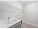 Functional laundry room featuring a utility sink and wire shelving for storage at 33945 Landsman Loop, Wesley Chapel, FL 33543