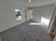 Well-lit bedroom featuring carpet and sliding door access at 3418 Eagle Pass St, North Port, FL 34286