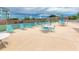 Community pool deck with lounge chairs, tables, and tennis courts at 3475 41St S Ter # 215, St Petersburg, FL 33711