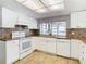 Modern white kitchen with granite countertops and a window at 4024 Jib Sail Ct, New Port Richey, FL 34652