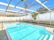 Screen-enclosed pool with crystal clear water surrounded by fencing, perfect for relaxation at 4024 Jib Sail Ct, New Port Richey, FL 34652