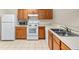 Kitchen with wood cabinets, white appliances, and tile floor at 4409 Winding River Way, Land O Lakes, FL 34639