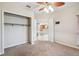 Neutral bedroom boasts ceiling fan, open closet, and doorway into the kitchen at 4534 Cozzo Dr, Land O Lakes, FL 34639