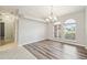 Open dining room with arched windows, a modern chandelier, and wood-style floors at 4534 Cozzo Dr, Land O Lakes, FL 34639