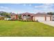 Inviting, red single-Gathering home boasting a well-manicured lawn and a three car garage at 4534 Cozzo Dr, Land O Lakes, FL 34639