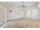 Spacious living room featuring neutral carpet, ceiling fan, and natural light from a sliding glass door at 4534 Cozzo Dr, Land O Lakes, FL 34639