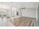 Open-concept living room featuring wood floors, decorative chandelier, and natural light at 4534 Cozzo Dr, Land O Lakes, FL 34639