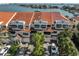 Aerial view of waterfront townhouses with red tile roofs and lush landscaping at 4625 Mirabella Ct, St Pete Beach, FL 33706