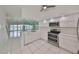 Modern white kitchen with stainless steel appliances and quartz countertops at 4625 Mirabella Ct, St Pete Beach, FL 33706