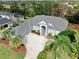 House with gray roof and driveway, surrounded by lush landscaping at 5253 Mira Vista Dr, Palm Harbor, FL 34685