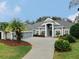 Gray house with a three-car garage, landscaping, and palm trees at 5253 Mira Vista Dr, Palm Harbor, FL 34685