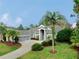 Single-Gathering home with gray siding, mature landscaping, and palm trees at 5253 Mira Vista Dr, Palm Harbor, FL 34685