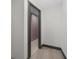 A hallway with light walls and dark wood flooring, leading to another room at 5809 Cruiser Way, Tampa, FL 33615