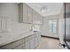 Modern laundry room with grey cabinets and marble counters at 5809 Cruiser Way, Tampa, FL 33615